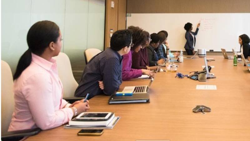 Alt text: Team engaged in a discussion about the key benefits of effective tech knowledge management 